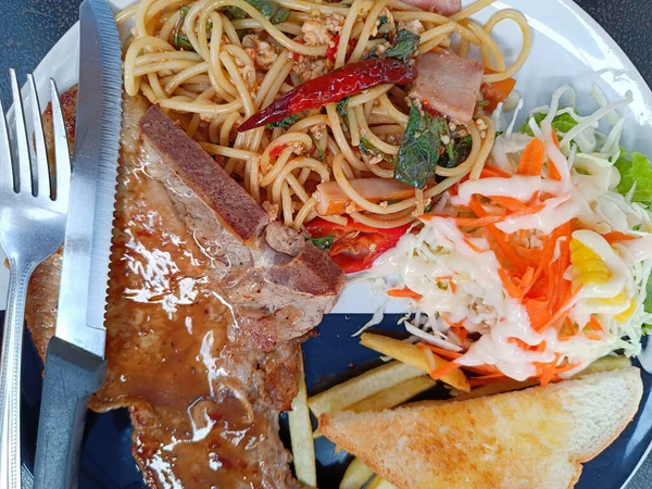 Ovanifrån Spaghetti Med Kryddig Fläsk Och Fläskkotlett Serveras Med Grönsakssallad — Stockfoto