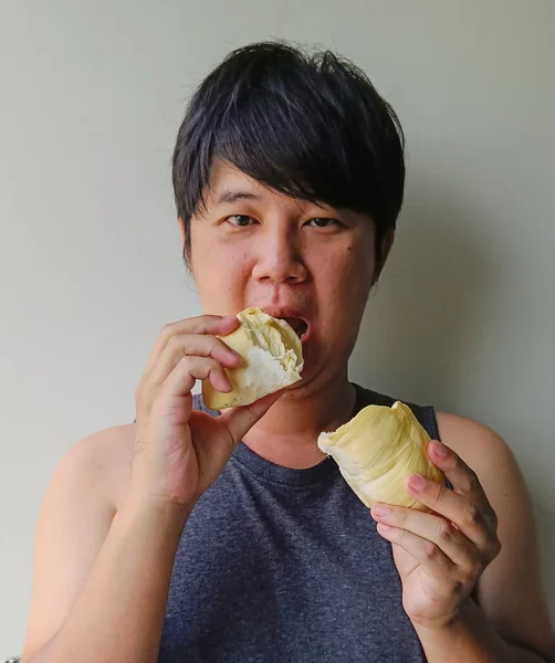 Young Asian men eat durian. Fruits with smell are popular in Thailand.