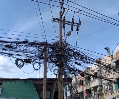 Direkteki dağınık elektrik kabloları Tayland 'daki elektrik direğindeki kablo ve kabloların karmaşası.