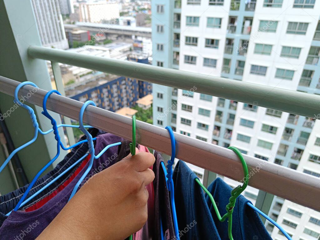 Asian housewives drying clothes on the balcony of a condo or apartment