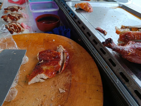 Roast duck on a wooden cutting board to prepare for slicing. Duck rice shop