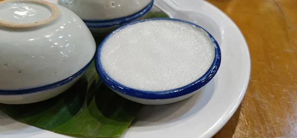 Closeup Thai Coconut Milk Custard or Khanom Thuai (Thai dessert) in a cup with sweet and creamy taste On the Thai dessert