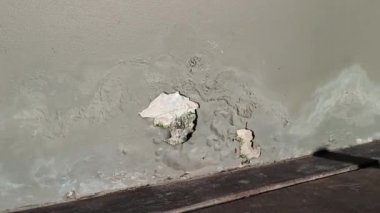 Eski binanın duvarları çatlak, kötü onarılmış, soyulmuş boyalar var..