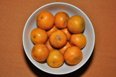 Olgun Tangerine, Mandarin, turuncu arka planda portakalların üst görüntüsü.