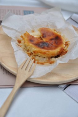 Ahşap bir tabakta ahşap çatallı nefis cheesecake, masada cheesecake