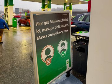 İsviçre 'de bir benzin istasyonunda yüz maskesi tabelası