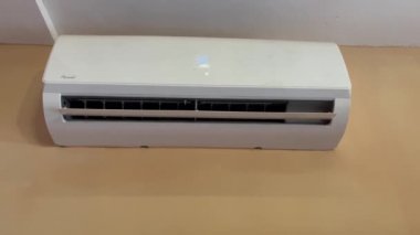 Beyaz klima bir otel odasının duvarına monte edilmiş.