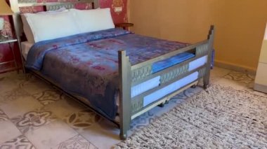 Beyaz yastıklı çift kişilik yatak ve otel odasında kırmızı bir duvar.