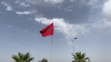 Dalgalı bir Fas bayrağının yanından geçen sanayi kamyonu.