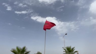 Arka planda mavi gökyüzü dalgalanan Fas bayrağı