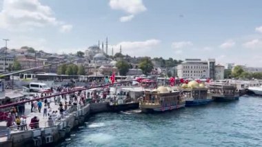İstanbul 'daki Eminn Yeni Camii yakınlarındaki İstanbul Boğazı' nın yanında takılan kalabalık