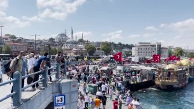 İstanbul 'daki Eminn Yeni Camii yakınlarındaki İstanbul Boğazı' nın yanında takılan kalabalık