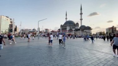 İstanbul 'da Taksim Camii yakınlarında yürüyen insanlar