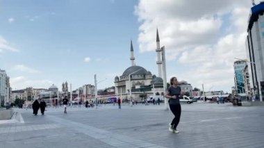 İstanbul 'da Taksim Camii yakınlarında yürüyen insanlar