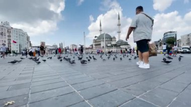 İstanbul 'da Taksim Camii yakınlarında yürüyen insanlar