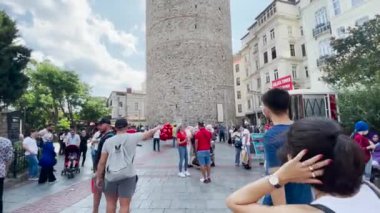 İstanbul 'un eski kentinde Galata Kulesi' nin yakınında yürüyen insanlar