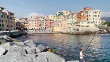 İtalya 'nın Boccadasse bölgesinin kıyısında balık tutan bir çocuk.