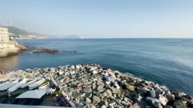 Boccadassa sahili üzerinde deniz kenarında küçük balıkçı tekneleri olan bir hava manzarası.