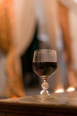 Oteldeki mermer masada bir kadeh kırmızı şarap.