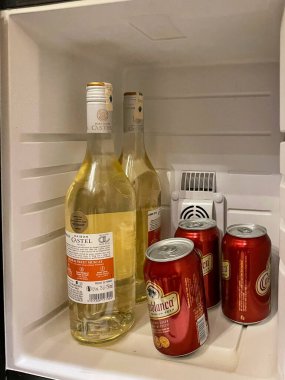 Oteldeki mini buzdolabında şarap şişeleri ve bira kutuları.