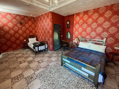 Beyaz yastıklı çift kişilik yatak ve otel odasında kırmızı bir duvar.