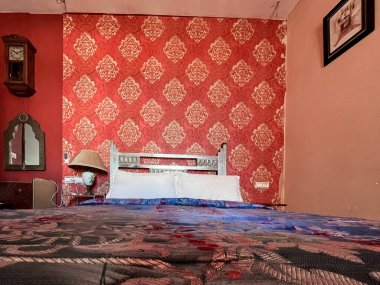 Beyaz yastıklı çift kişilik yatak ve otel odasında kırmızı bir duvar.