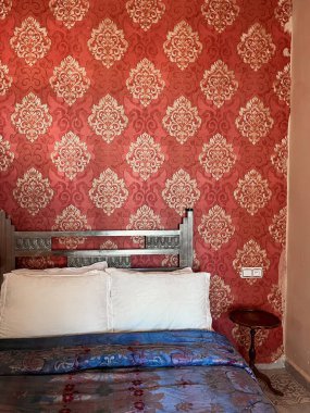 Beyaz yastıklı çift kişilik yatak ve otel odasında kırmızı bir duvar.