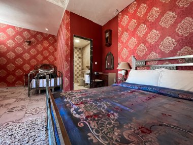 Konforlu yatakları ve lüks banyosu olan üç kişilik bir otel odası.