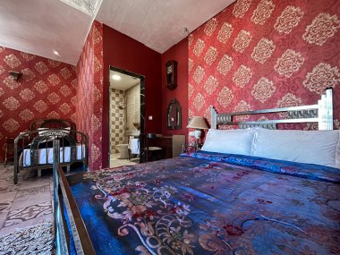 Beyaz yastıklı çift kişilik yatak ve otel odasında kırmızı bir duvar.