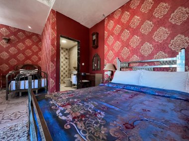 Beyaz yastıklı çift kişilik yatak ve otel odasında kırmızı bir duvar.