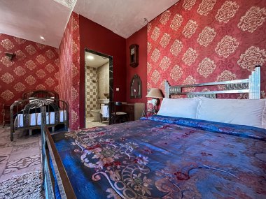 Beyaz yastıklı çift kişilik yatak ve otel odasında kırmızı bir duvar.