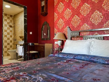 Beyaz yastıklı çift kişilik yatak ve otel odasında kırmızı bir duvar.