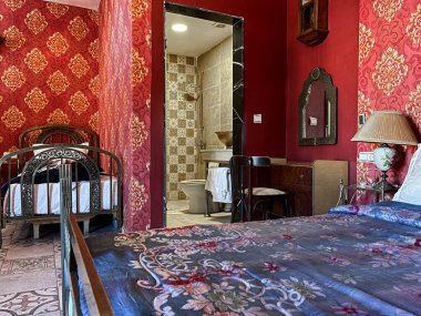 Beyaz yastıklı çift kişilik yatak ve otel odasında kırmızı bir duvar.