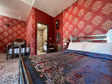 Beyaz yastıklı çift kişilik yatak ve otel odasında kırmızı bir duvar.