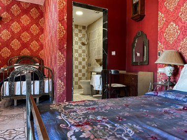 Beyaz yastıklı çift kişilik yatak ve otel odasında kırmızı bir duvar.