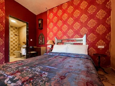 Beyaz yastıklı çift kişilik yatak ve otel odasında kırmızı bir duvar.