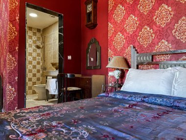 Beyaz yastıklı çift kişilik yatak ve otel odasında kırmızı bir duvar.