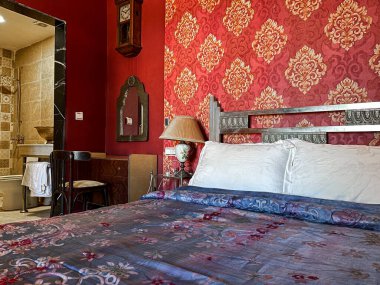 Beyaz yastıklı çift kişilik yatak ve otel odasında kırmızı bir duvar.