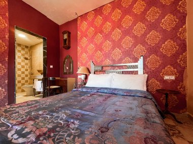 Beyaz yastıklı çift kişilik yatak ve otel odasında kırmızı bir duvar.