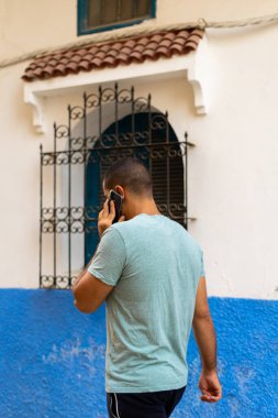 Asilah sokaklarında yürüyen Faslı bir adam.