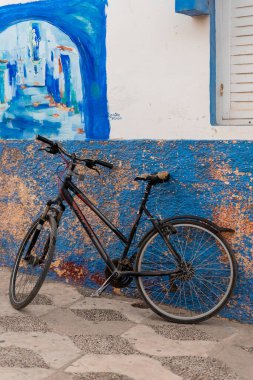 Assilah 'ın eski Medine' sinde duvara yaslanan eski siyah bisiklet