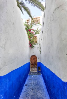 Asilah 'ın Medine' sinde mavi beyaz geçitli kahverengi ahşap kapı.