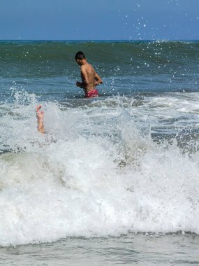 Genç çocuk bir sonraki dalgaya doğru koşuyor.