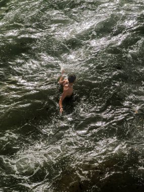 Genç adam okyanusta tek başına yüzüyor.
