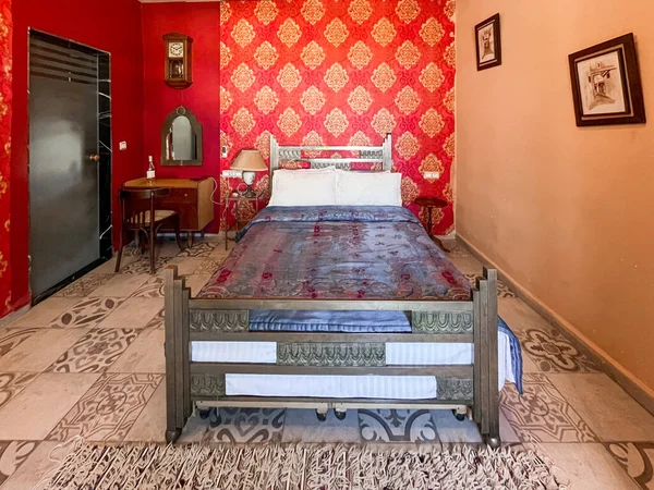 ホテルの部屋には白い枕と赤い壁があるダブルベッド — ストック写真