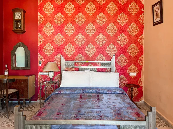 Beyaz yastıklı çift kişilik yatak ve otel odasında kırmızı bir duvar.