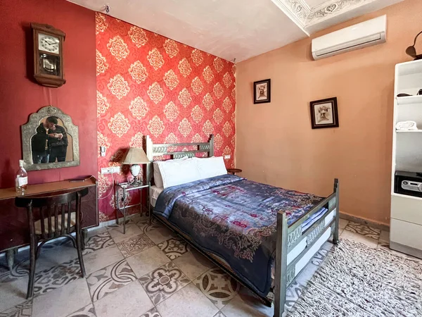 Beyaz yastıklı çift kişilik yatak ve otel odasında kırmızı bir duvar.