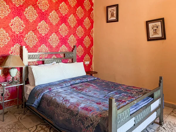ホテルの部屋には白い枕と赤い壁があるダブルベッド — ストック写真