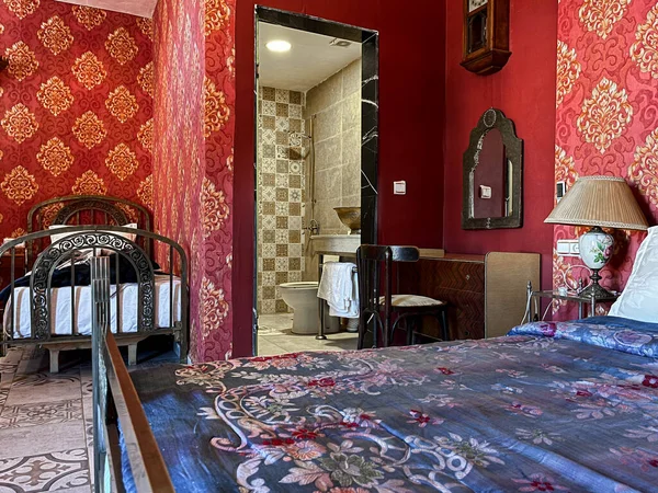 Beyaz yastıklı çift kişilik yatak ve otel odasında kırmızı bir duvar.