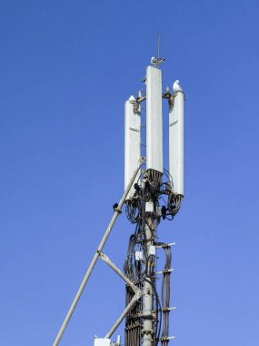 Arka planda mavi gökyüzü olan 4G + vericiler kulesi